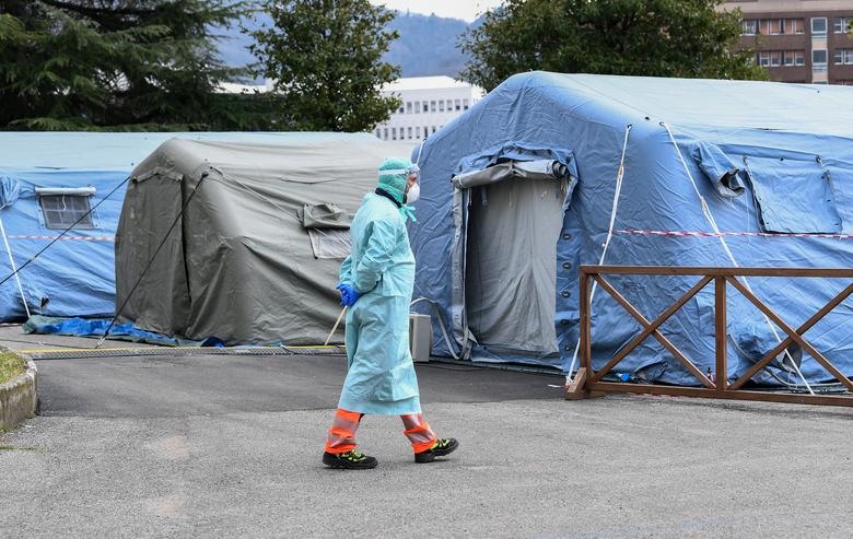 Một nhân viên y tế bên ngoài bệnh viện Spedali civili ở Brescia, ngày 13 tháng 3. Các lều đã được dựng lên hơn một tuần trước để đối phó với dòng người liên tục, cảm thấy bị bệnh và tin rằng họ đã nhiễm virus. REUTERS / Flavio Lo Scalzo