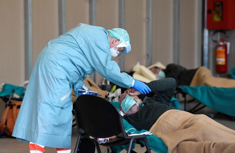Nhân viên y tế giúp đỡ bệnh nhân trong bệnh viện Spedali Civilili ở Brescia, ngày 13 tháng 3. REUTERS / Flavio Lo Scalzo