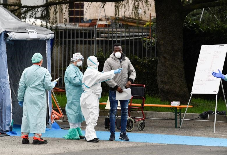Nhân viên y tế hỗ trợ một bệnh nhân tại bệnh viện Spedali civili ở Brescia, ngày 13 tháng 3. REUTERS / Flavio Lo Scalzo