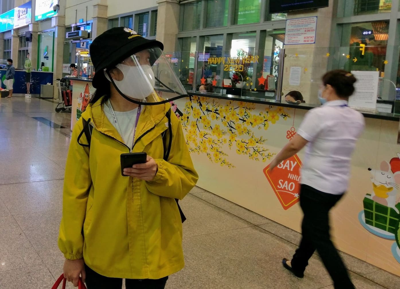 Trong khi đó, để phòng dịch, một số hành khách ở sân bay Tân Sơn Nhất ngoài việc đeo khẩu trang còn trang bị thêm mũ bảo hộ.