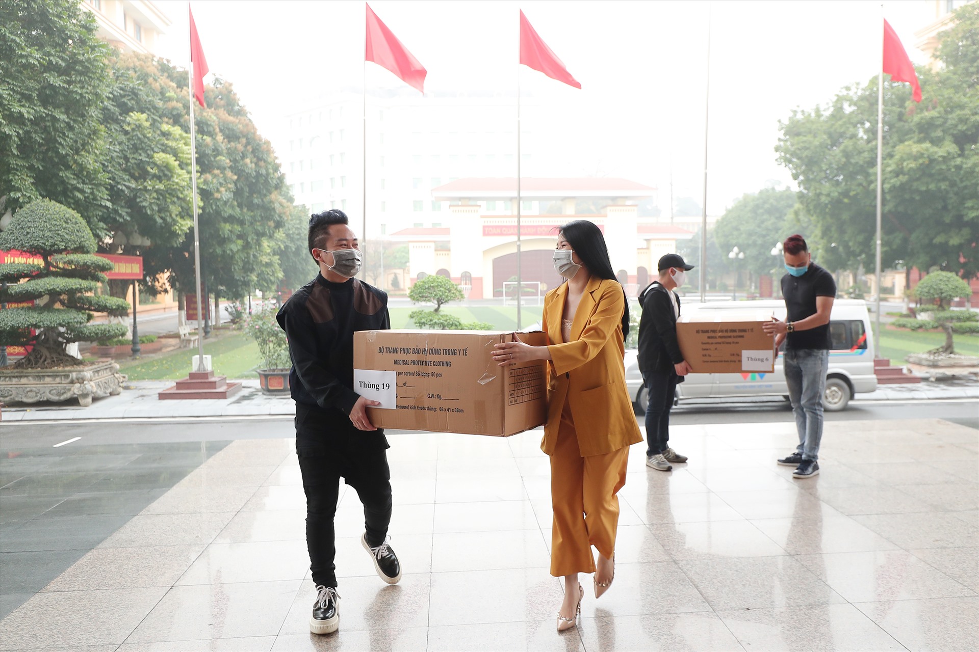 Ca sĩ Tùng Dương và Phạm Thuỳ Dung trao 1.000 chiếc áo bảo hộ và 2.000 khẩu trang cho Bộ Tư lệnh Biên phòng miền Bắc. Ảnh: Hoà Nguyễn.