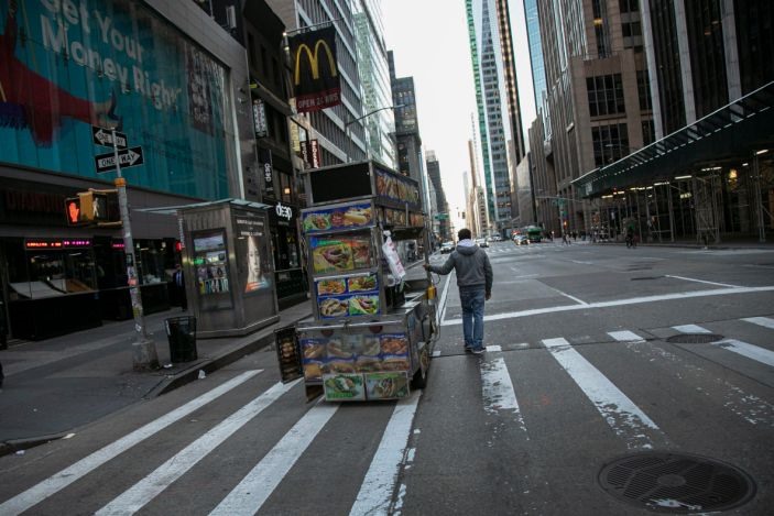 Người bán đồ ăn đang đẩy xe hàng trên một con phố vắng vẻ ở Quảng trường Thời đại, New York, ngày 15.3. Ảnh: USA Today