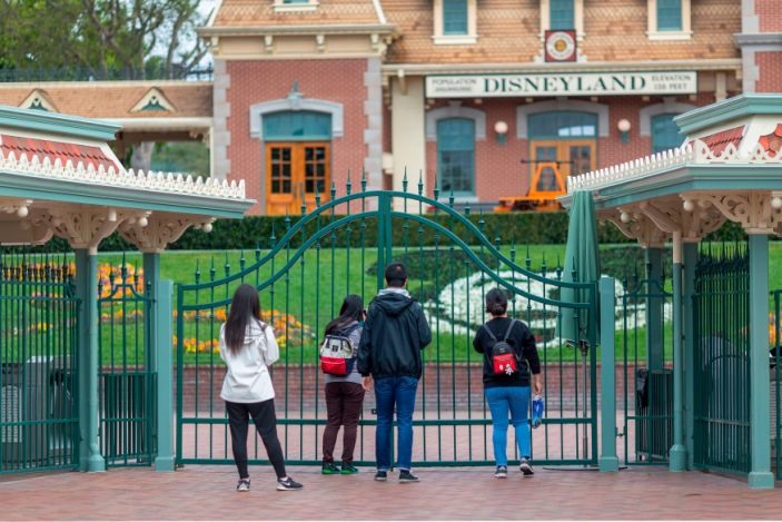 Du khách đứng trước cổng công viên giải trí Disneyland đã đóng cửa vào 14.3. Ảnh: USA Today