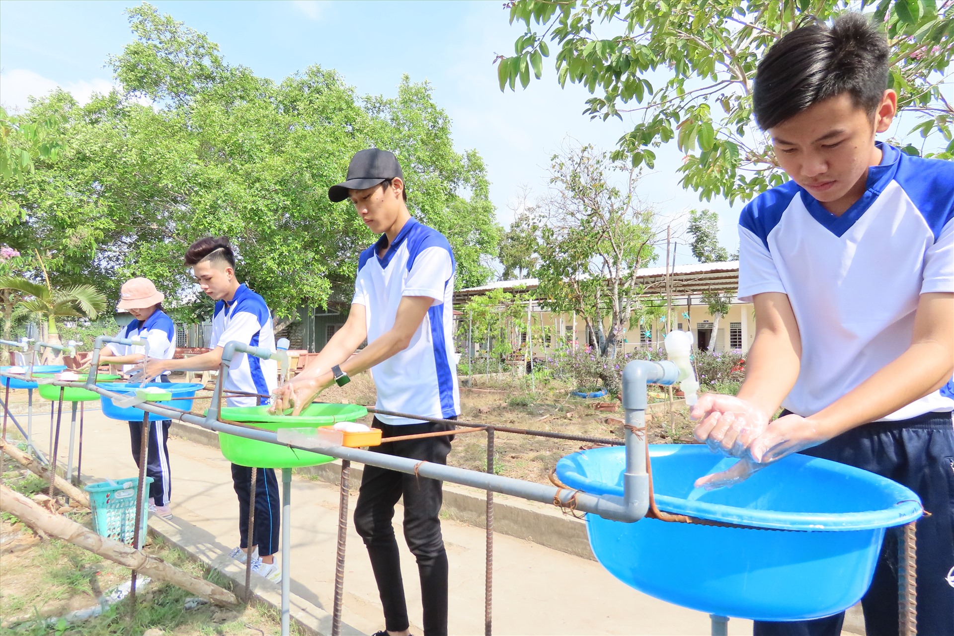Bồn rửa tay tại trường THPT Tân Long do các thầy cô trong trường tự làm, để trang bị cho các em học sinh đến trường đi học. Ảnh: S.H