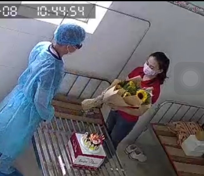 Bác sĩ tặng hoa, bánh kem chúc mừng sinh nhật cô gái cách ly đúng ngày 8.3. Ảnh cắt từ camera khu cách ly.