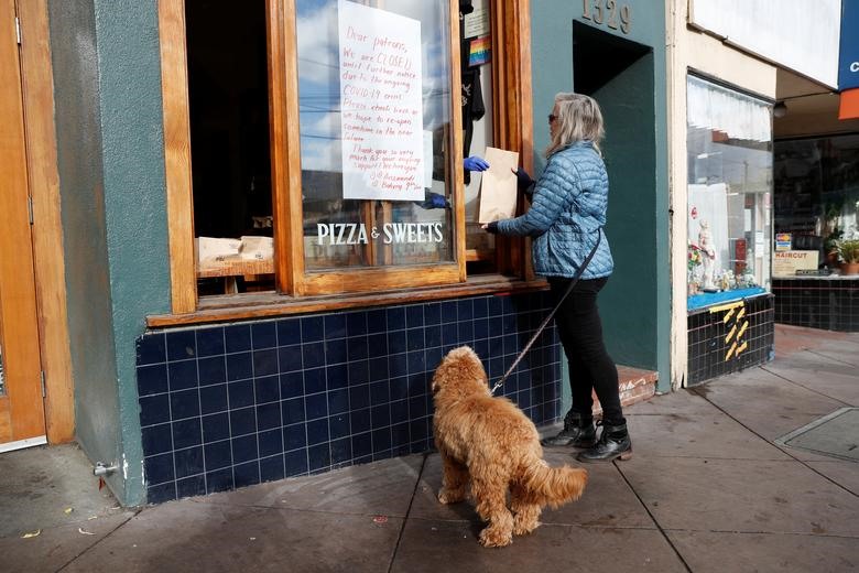 Khách hàng nhận túi bánh ngọt miễn phí từ cửa hàng bánh Arizmendi đang chuẩn bị đóng cửa tạm thời ở San Francisco, California, ngày 17.3. Ảnh: Reuters