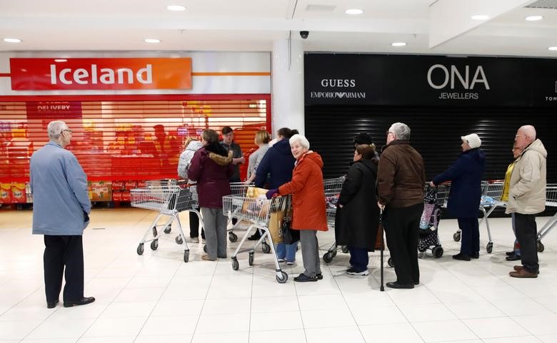 Người cao tuổi đứng xếp hàng bên ngoài cửa hàng Iceland ở trung tâm Kennedy, tại Belfast, bắc Ireland, Vương quốc Anh, ngày 17.3. Cửa hàng dành 1 giờ đầu tiên sau khi mở cửa đẻ phục vụ riêng người cao tuổi. Ảnh: Reuters