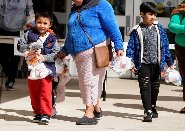Trẻ em tới nhận bữa ăn sáng và ăn trưa tại trường Trung học Kenmore sau khi nhà trường đóng cửa ở Arlington, Virginia, ngày 17.3. Ảnh: Reuters