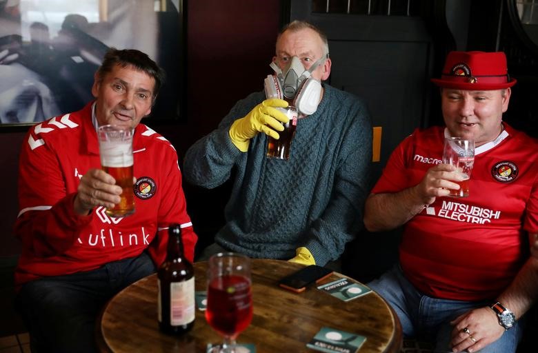 Người hâm mộ đội bóng Ebbsfleet đeo khẩu trang uống cùng nhau trước trận gặp câu lạc bộ Halifax, Anh. Ảnh: Reuters/Phil Noble.