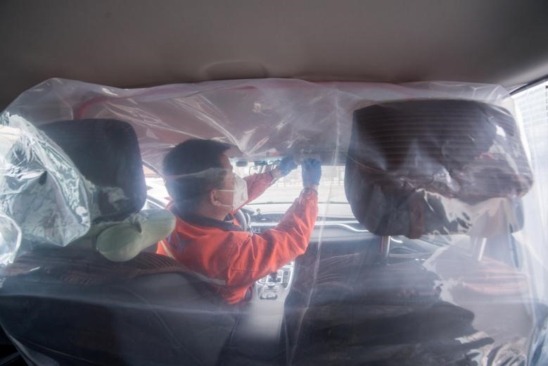 Lái xe lắp vách ngăn trong ô tô tại tỉnh Sơn Tây, Trung Quốc. Ảnh: Reuters.
