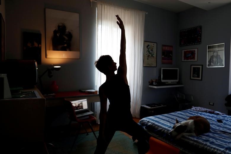 Francesca Valagussa, 40 tuổi, tập yoga thông qua 1 khóa học trực tuyến ở Italia hôm 16.3. Ảnh: Reuters/Yara Nardi.