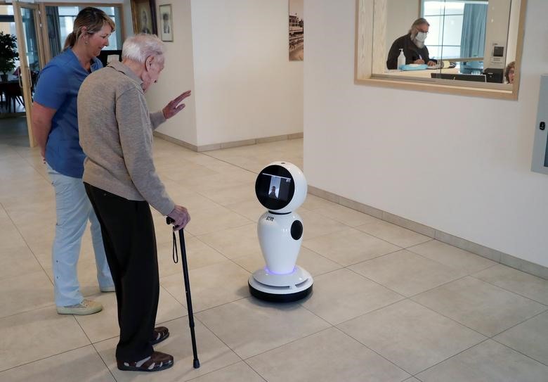 Cụ Jozef Gouwy, 93 tuổi, liên lạc với người thân qua robot tại Ostend, Bỉ, hôm 16.3. Ảnh: Reuters/Yves Herman.