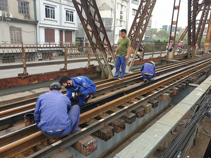 Một top công nhân khác cũng thực hiện việc duy tu, quét sơn lại đường ray tàu.