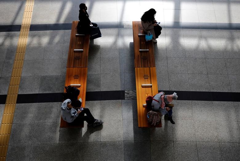 Hành khách giữ khoảng cách trên băng ghế đợi trong sảnh của nhà ga ở Daegu, Hàn Quốc. Ảnh: REUTERS/Kim Kyung-Hoon.