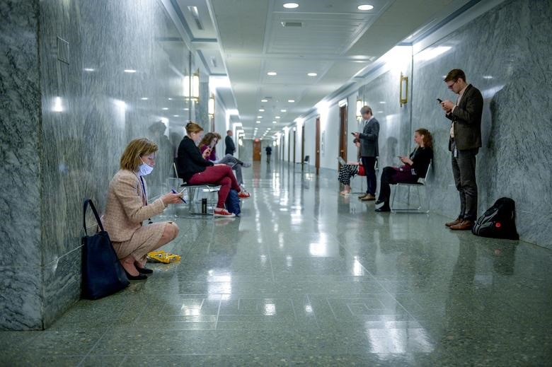 Các nhà báo đứng cách xa nhau tại hành lang bên ngoài một cuộc họp tại Washington, Mỹ. Ảnh: REUTERS/Mary F. Calvert.
