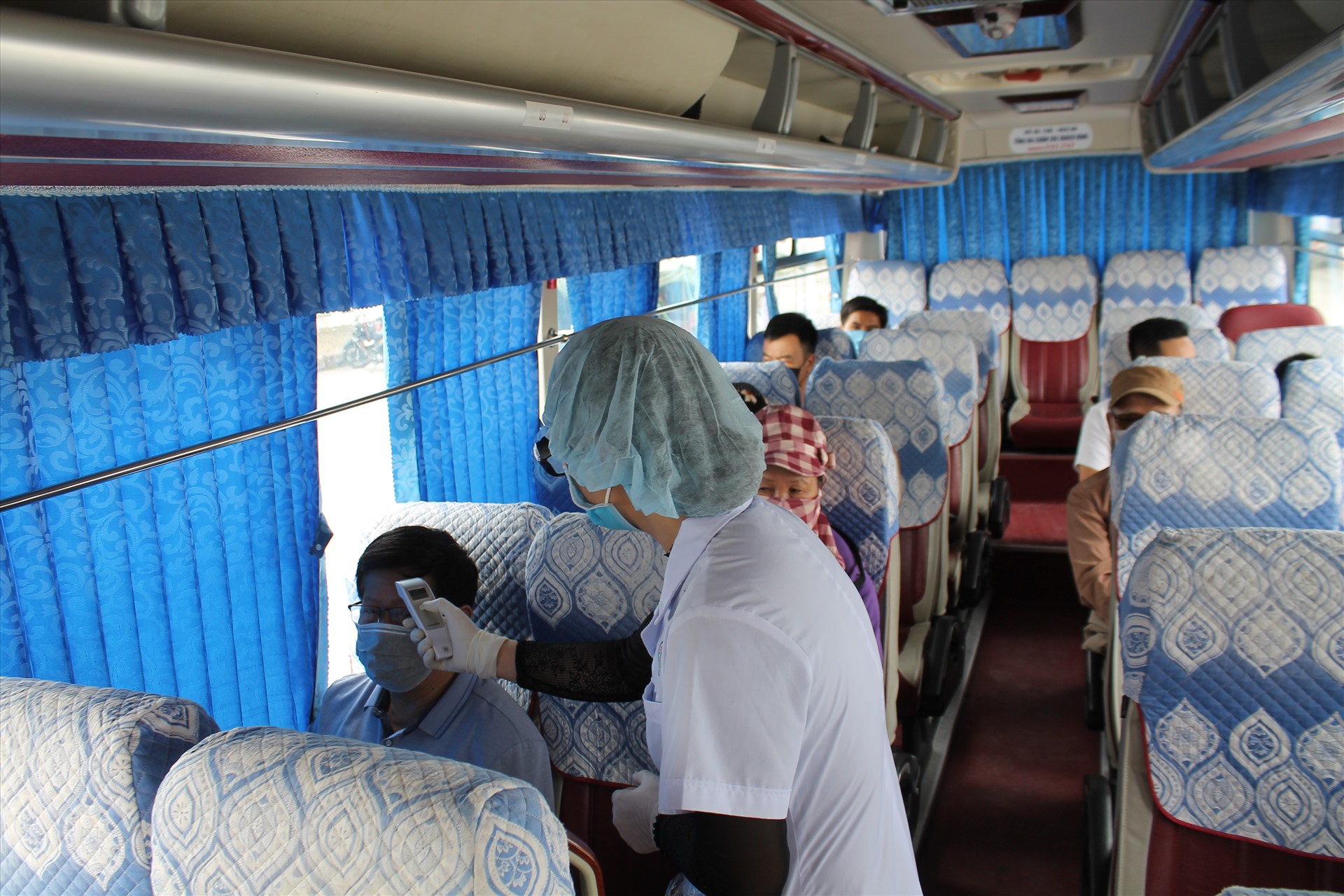 Cán bộ y tế tại Chốt kiểm dịch số 3 (đặt sau Trạm thu phí cao tốc Hà Nội - Hải Phòng nhánh xuống đường 353 quận Dương Kinh) kiểm tra thân nhiệt các hành khách trên phương tiện vận tải vào thành phố. Ảnh Mai Dung