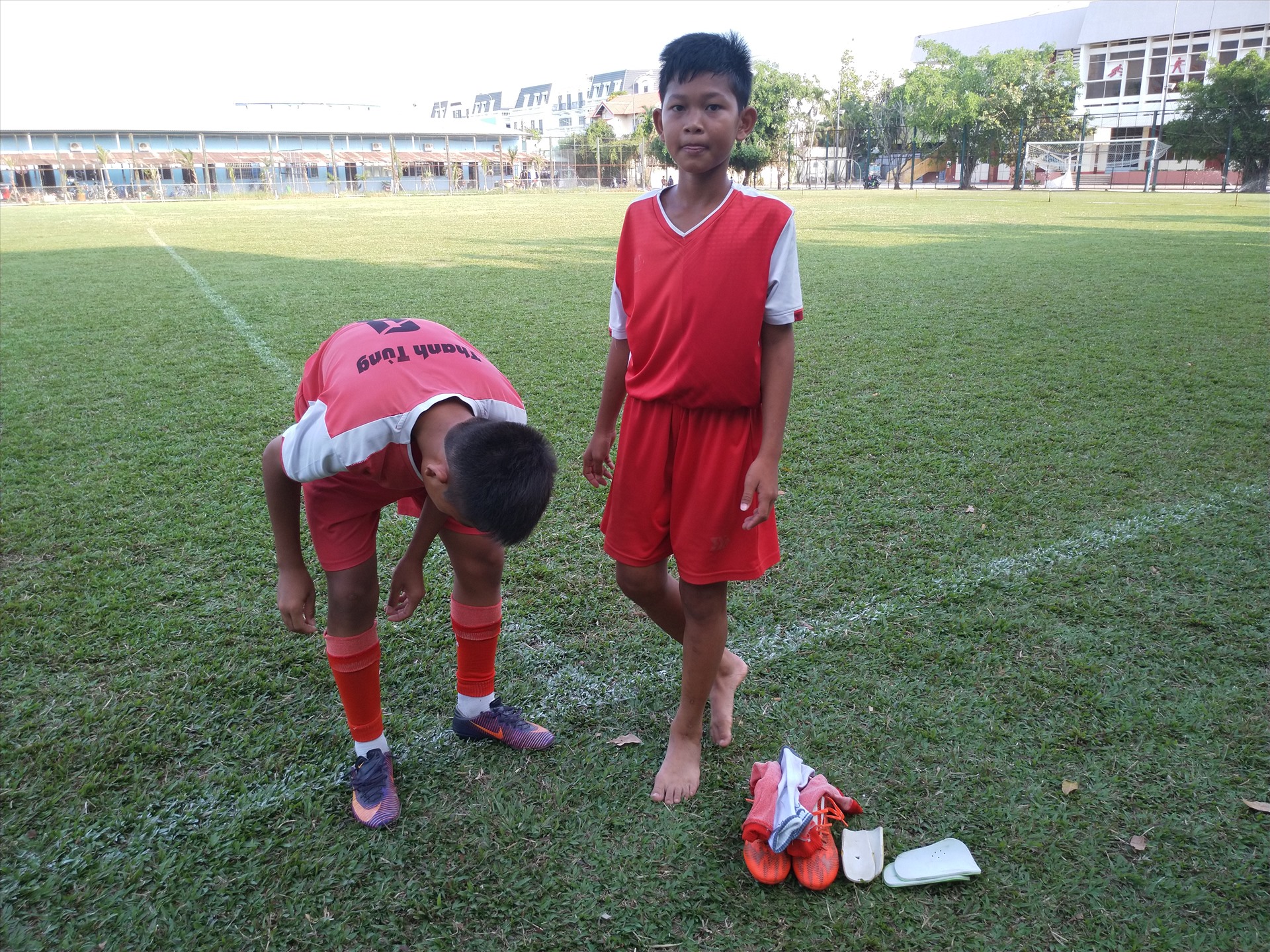 Hai cầu thủ U-13 là Nguyễn Thanh Tùng và Nguyễn Hữu Trí cỡi giày trả lại cho đội để về nhà tạm nghỉ. Ảnh: K.Q