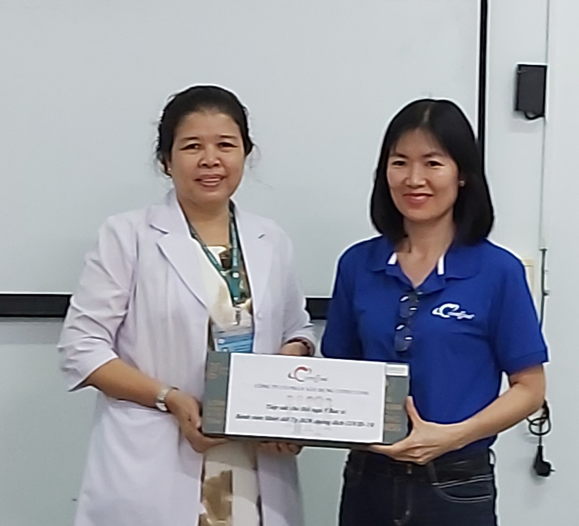 Bà Nguyễn Thị Ngọc Tuyết, Chủ tịch Công đoàn Công ty Coteccons (bên phải) tặng sữa cho nhân viên y tế Bệnh viện Nhiệt đới TPHCM. ảnh Nam Dương