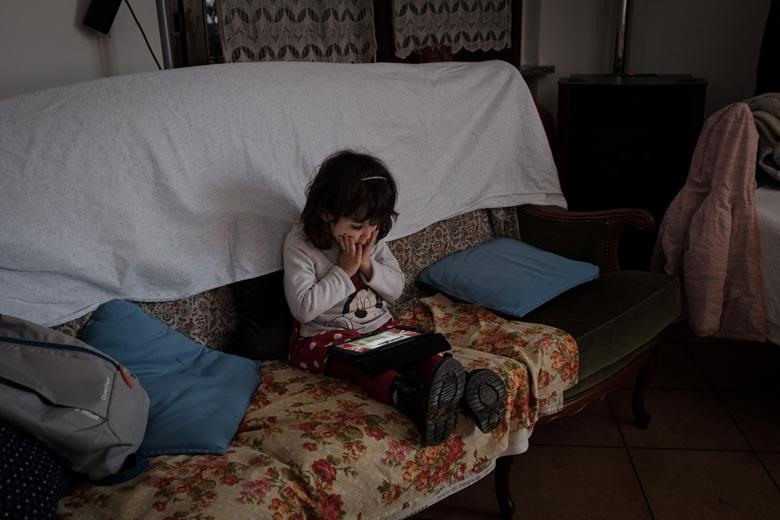 Bianca Toniolo, 2 tuổi, ngồi trên ghế sofa tại nhà ở San Fiorano, ngày 23.2. Ảnh: Reuters