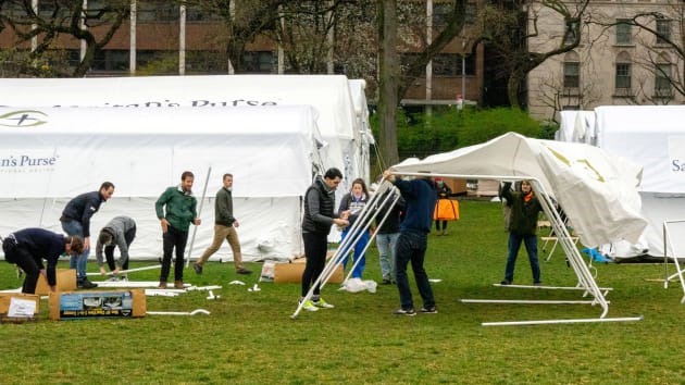 Tình nguyện viên dựng các lều bạt cỡ lớn trong quá trình dựng bệnh viện dã chiến ở Công viên Trung tâm hôm 30.3. Ảnh: Reuters.