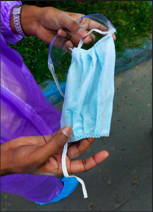 Một bác sĩ tại một bệnh viện lớn ở Kolkata, Ấn Độ phải dùng chiếc khẩu trang y tế cũ đã đứt quai đeo. Ảnh: Reuters