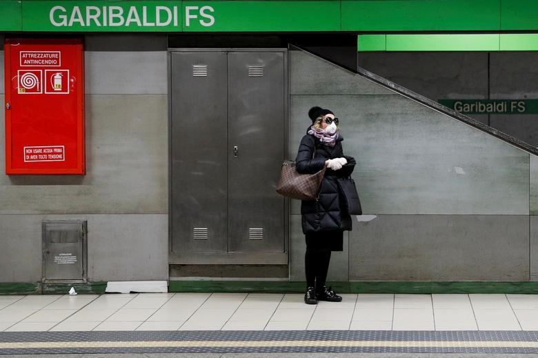 Một người phụ nữ đeo khẩu trang đứng chờ một chuyến tàu tại ga tàu điện ngầm Garibaldi (Milan, Italia) hôm 3.3.