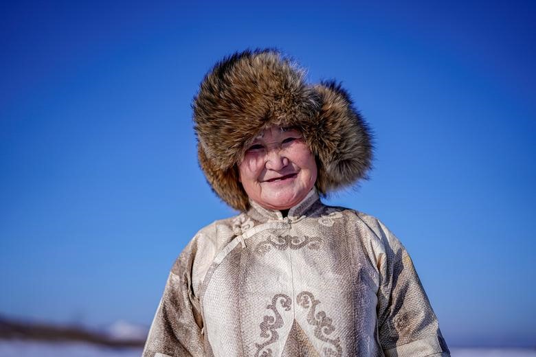 You Wenfeng, 68 tuổi, một phụ nữ dân tộc Heanch, chụp ảnh với bộ quần áo da cá của cô tại một con sông đóng băng ở Tongjiang, tỉnh Hắc Long Giang, Trung Quốc ngày 1 tháng 1 năm 2020. Bạn, người thuộc dân tộc Heanch nhỏ bé của Trung Quốc, là một trong Một số ít người trong cộng đồng của cô vẫn có thể làm quần áo từ da cá. Rất ít người trong thế hệ hiện tại quan tâm đến việc học nghề và quần áo truyền thống không còn là một phần thường xuyên của trang phục Heanch hàng ngày.