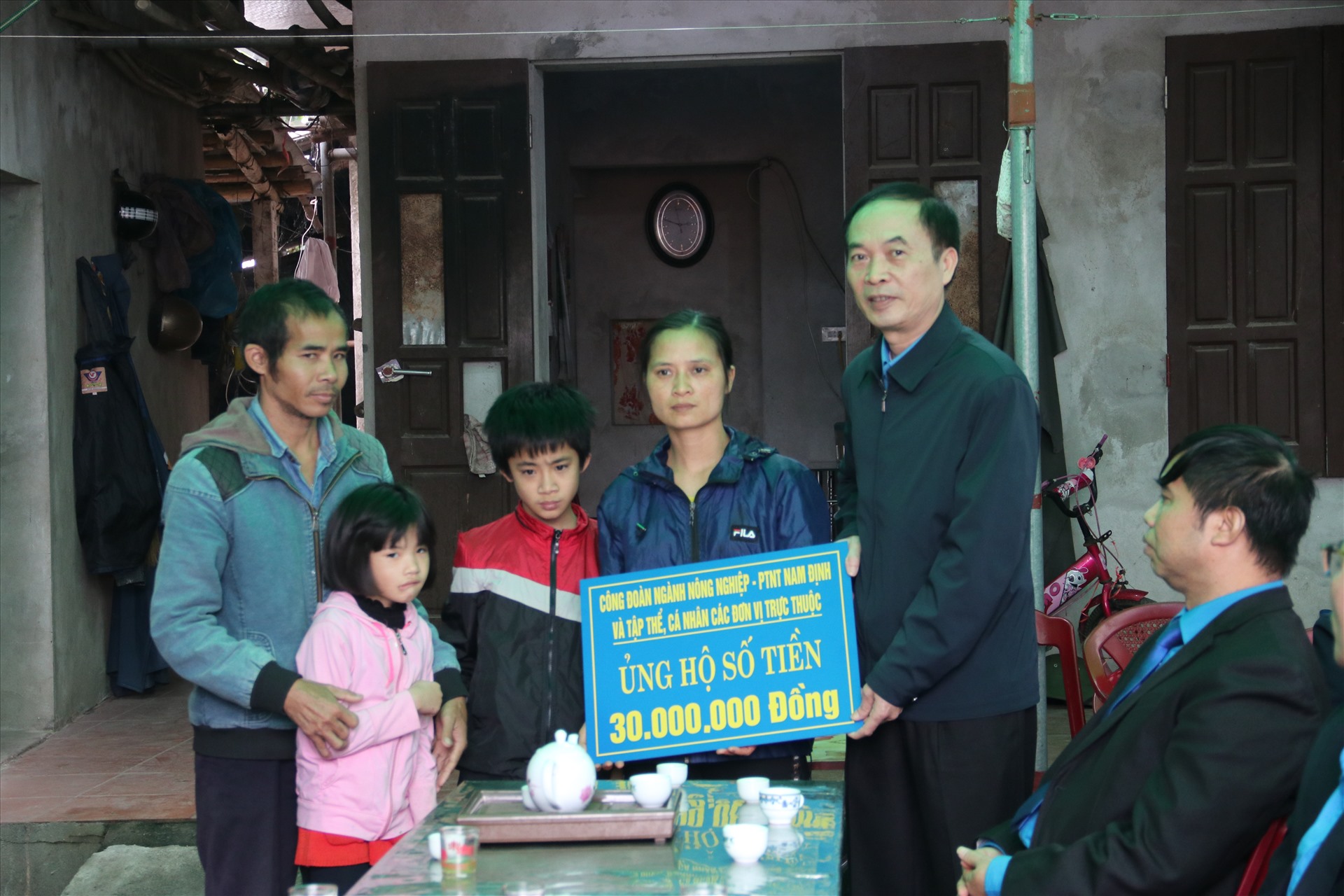 Đồng chí Vũ Văn Kham - Chủ tịch Công đoàn ngành Nông nghiệp và phát triển nông thôn tỉnh - trao tiền hỗ trợ cho gia đình chị Hảo.