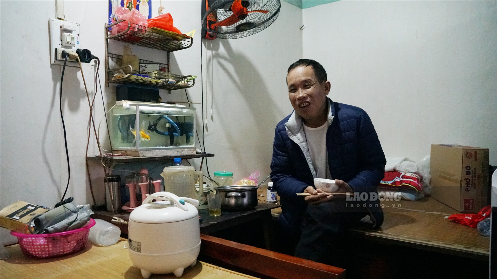 Anh Hoàng Văn Tuấn (46 tuổi, Nam Định) nở nụ cười tươi khi đang dùng bữa trưa. Anh Tuấn hi vọng, dịch COVID-19 mau đi qua để anh Tuấn tiếp tục chạy xe trở khách, có thêm thu nhập chữa trị bệnh thận của mình.