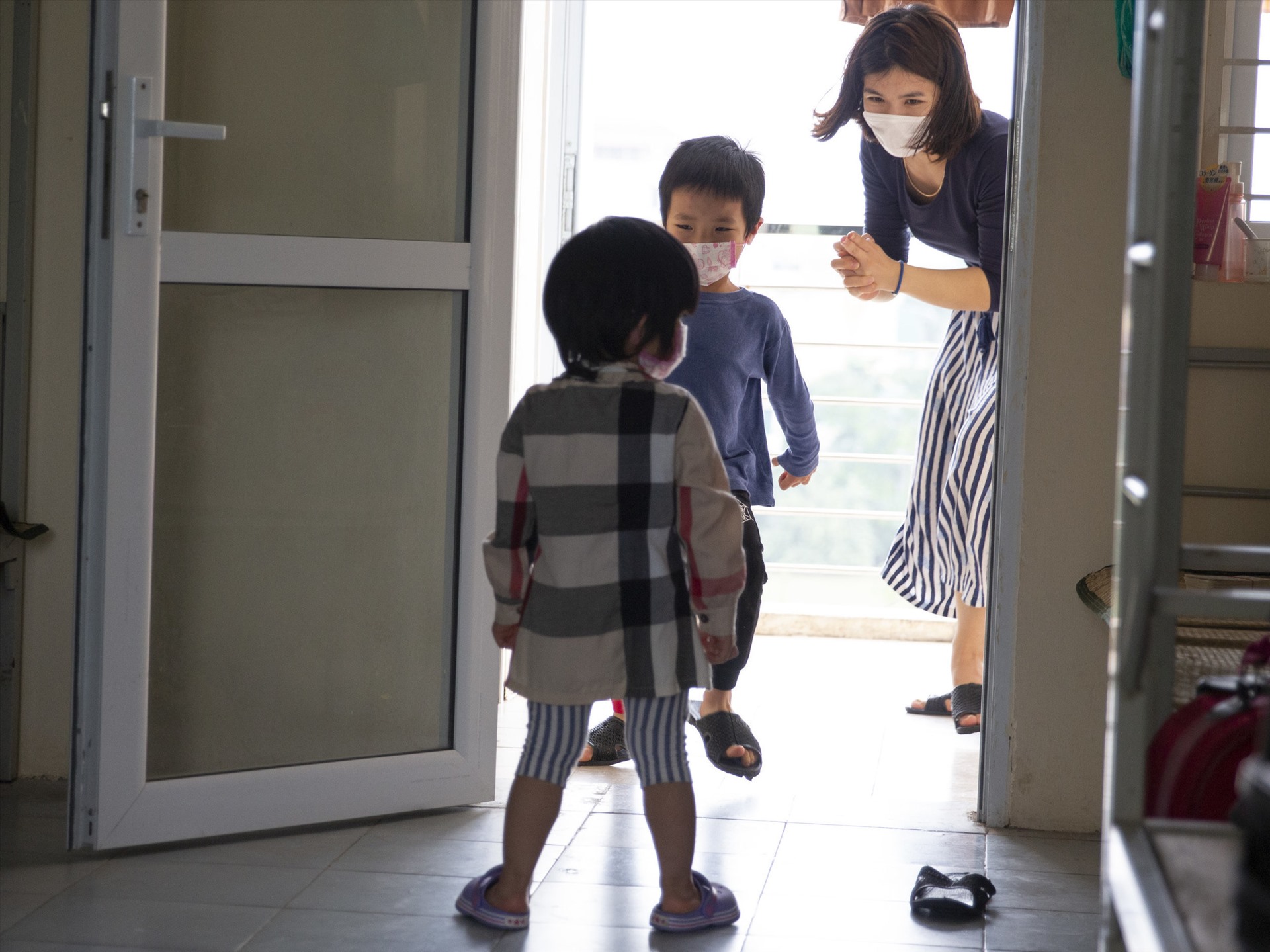 Người mẹ đang chơi với hai đứa con 2 và 5 tuổi tại phòng ở khu cách ly. Ảnh: Kai Nguyen/NPR.