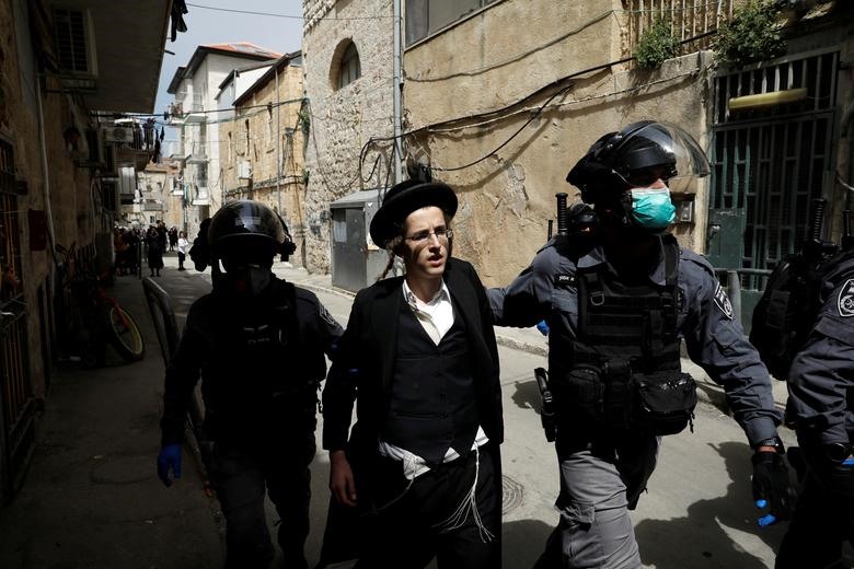 Cảnh sát Israel bắt giữ một người đàn ông Do Thái cực đoan khi thực thi lệnh phong tỏa một phần tại khu phố Mea Shearim (Jerusalem) để hạn chế sự lây lan dịch bệnh. Ảnh: Reuters.