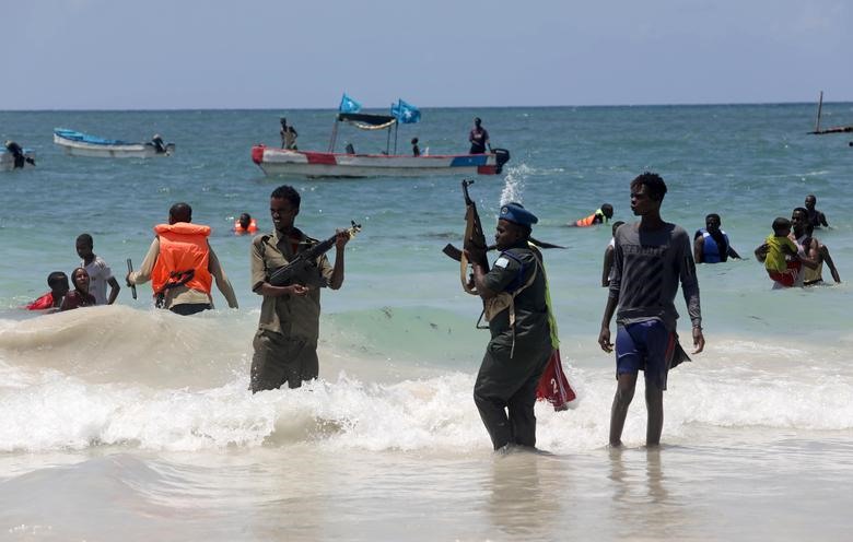 Cảnh sát Somalia cố gắng giải tán những người dân bơi gần bãi biển Lido. Ảnh: Reuters.
