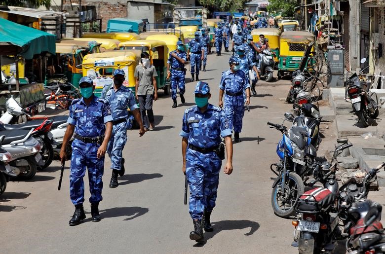 Lực lượng phản ứng nhanh tuần tra một khu phố để kêu gọi mọi người ở trong nhà tại thành phố Ahmedabad (Ấn Độ). Ảnh: Reuters.