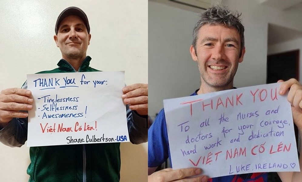 Anh Shane Patrick Culbertson (trái), cây viết mảng du lịch người Mỹ đã nghỉ hưu và anh Luke Kenny (phải) , giáo viên người Ireland sống tại Hà Nội, với những thông điệp cảm ơn nỗ lực của các nhân viên y tế và cổ vũ: “Việt Nam cố lên!“. Ảnh: Wayne Worrell
