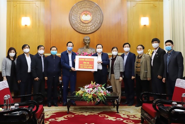 Chủ tịch UBTƯ MTTQ Việt Nam Trần Thanh Mẫn tiếp nhận số tiền ủng hộ từ Bộ trưởng Bộ Lao động - Thương binh và Xã hội Đào Ngọc Dung. Ảnh: MTTQ