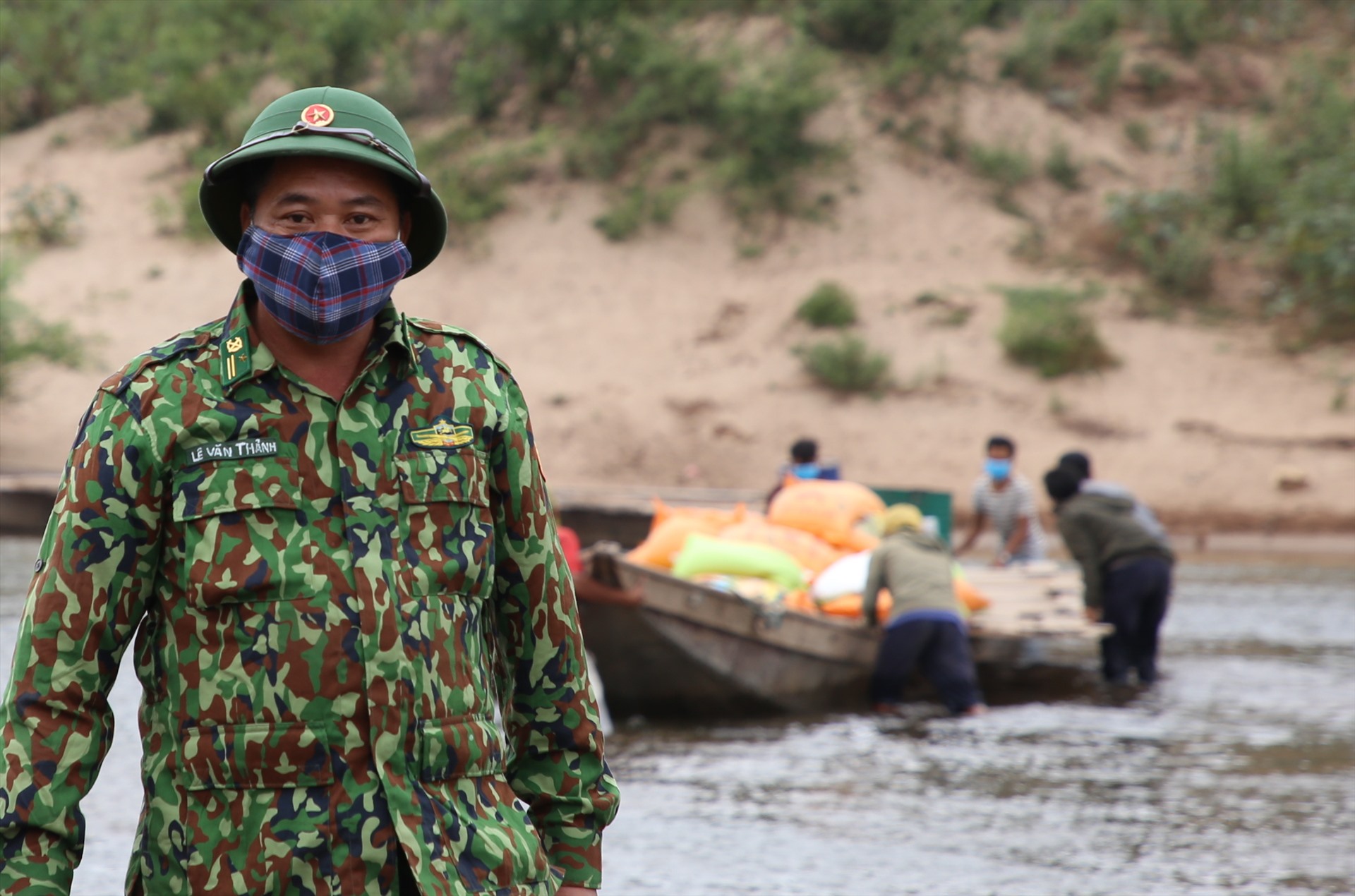 Thiếu tá Lê Văn Thảnh - phụ trách Trạm Cửa khẩu Thanh - Đồn Biên phòng Thanh hỗ trợ đẩy thuyền chở hàng sang giữa dòng sông thì quay trở lại.