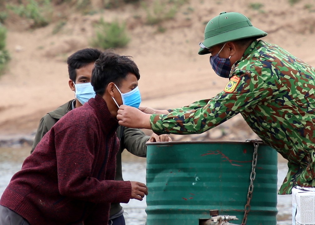 Một số người trong đoàn của huyện Mường Nòng chưa có khẩu trang, nên Biên phòng Quảng Trị ra giữa dòng sông hỗ trợ đeo khẩu trang đúng quy định phòng dịch COVID-19.