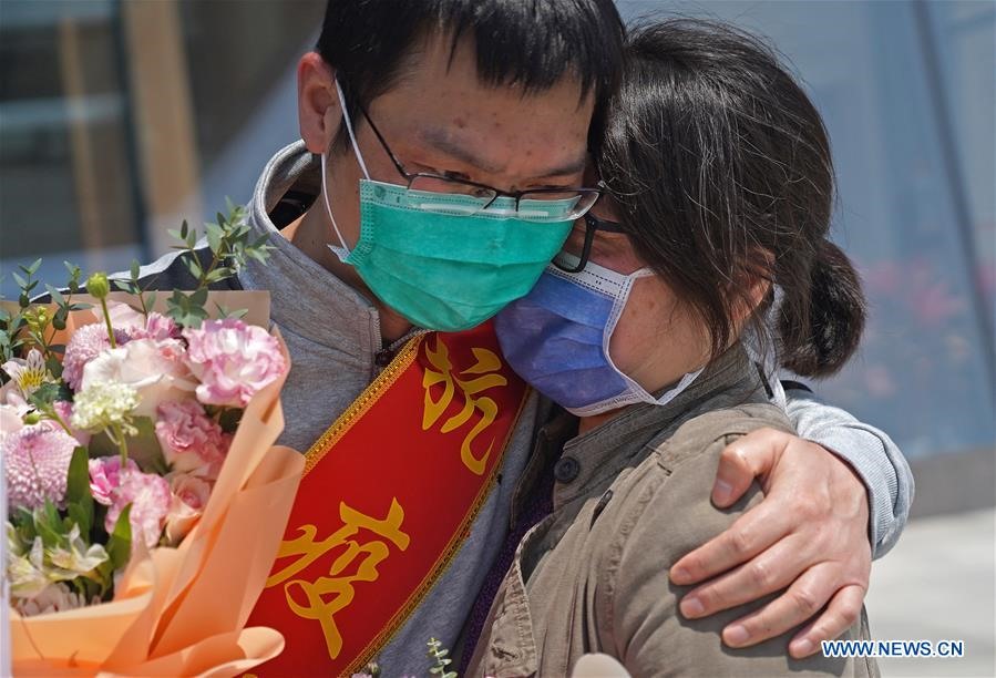 Zeng Zhenguo (trái), thành viên của nhóm hỗ trợ y tế chống dịch COVID-19 tại Vũ Hán ôm vợ sau khi cách ly 14 ngày tại khu vực Xianghu của Bệnh viện liên kết thứ nhất của Đại học Nam Xương ở Nam Xương, tỉnh Giang Tây hôm 15.4. Ảnh: Xinhua.