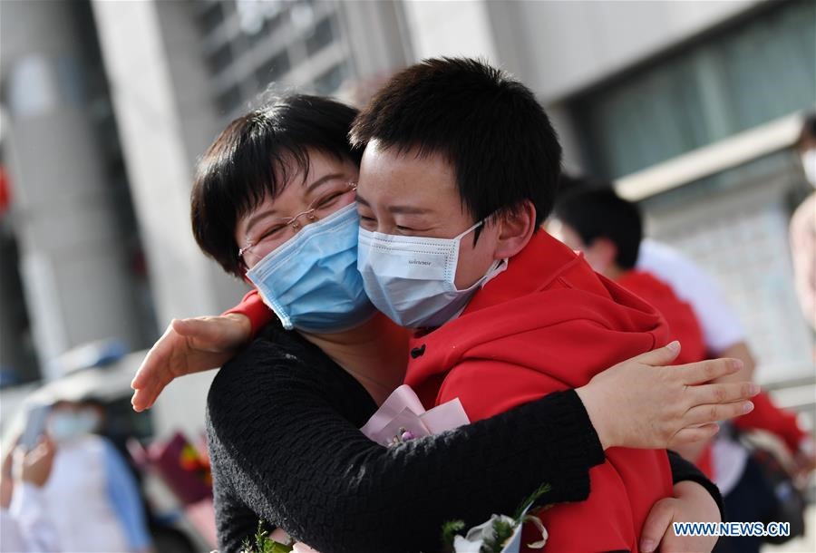 Wei Fei (phải) ôm chia vui với đồng nghiệp ở Tây An, tỉnh Thiểm Tây hôm 15.4. 130 nhân viên y tế Tây An hỗ trợ chống dịch COVID-19 tại Hồ Bắc đã đoàn tụ với gia đình, người thân sau 14 ngày cách ly. Ảnh: Xinhua.