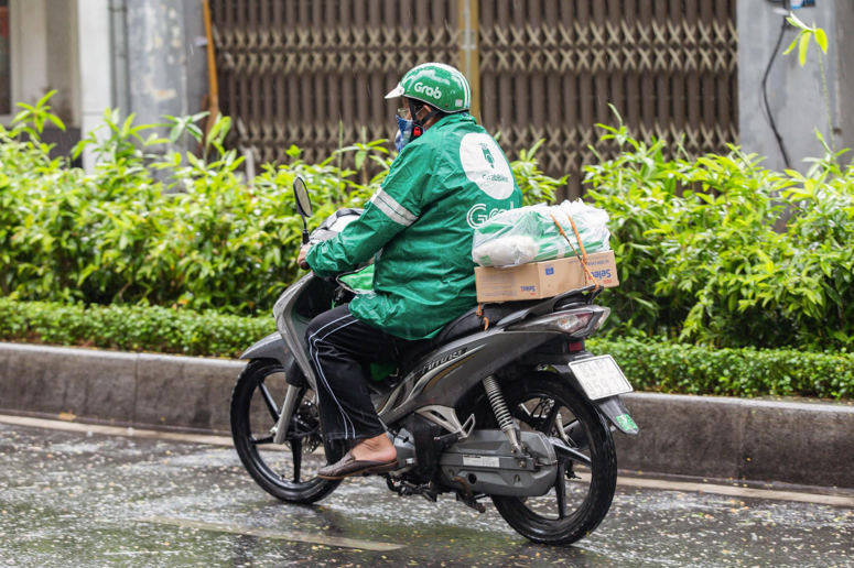 Tài xế công nghệ đội mưa chở về những phần gạo và mì do Grab “tiếp tế“, trưa ngày 12.4.