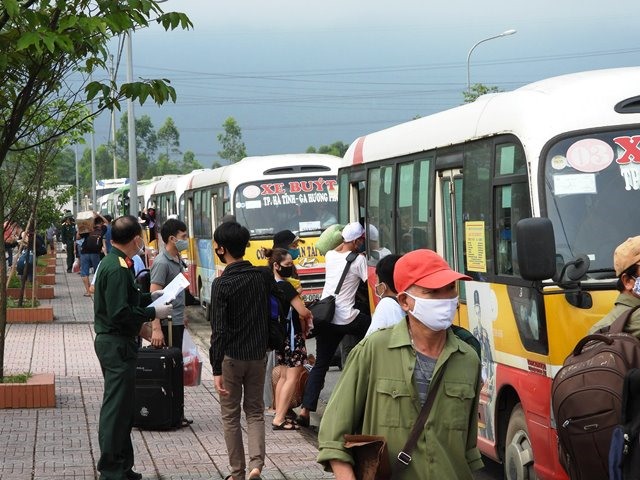 Những công dân ở xa được bố trí xe bus đưa về. Ảnh: TĐ
