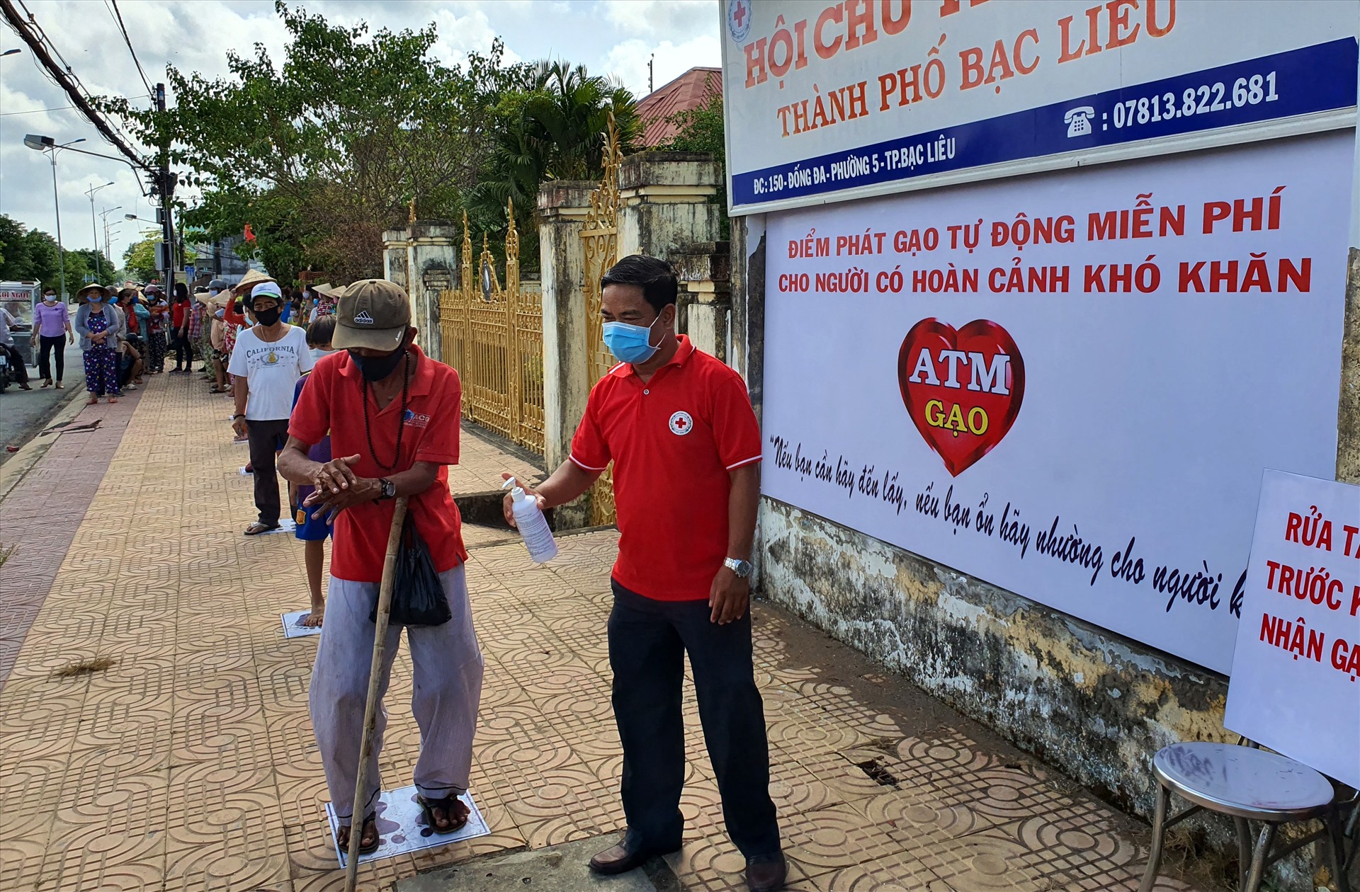 Người đến nhận gạo được rửa tay, hướng dẫn (ảnh Nhật Hồ)
