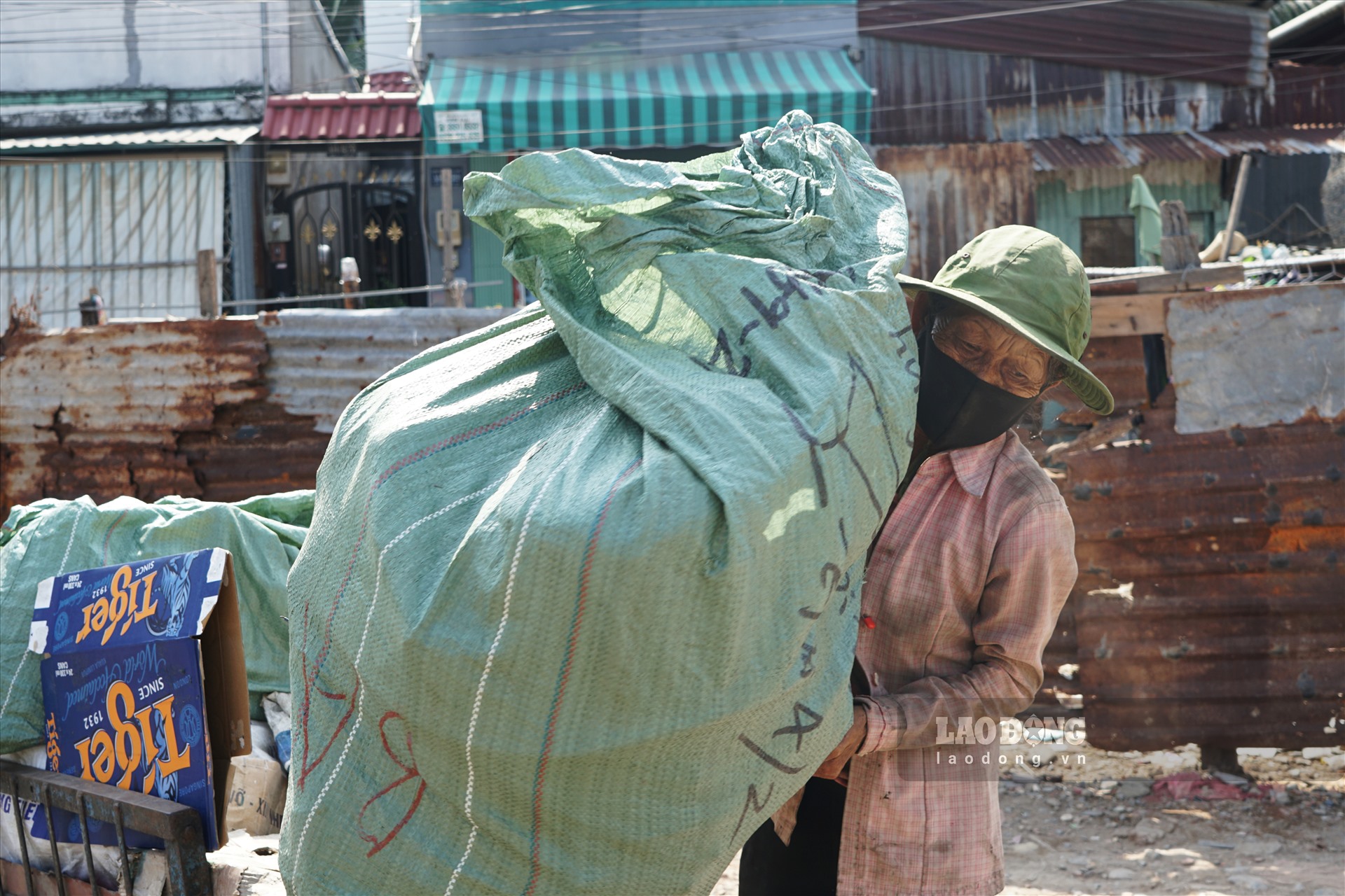 Bà Nguyễn Thị Mai thu dọn số ve chai nhặt được. Ảnh: Hà Phương.