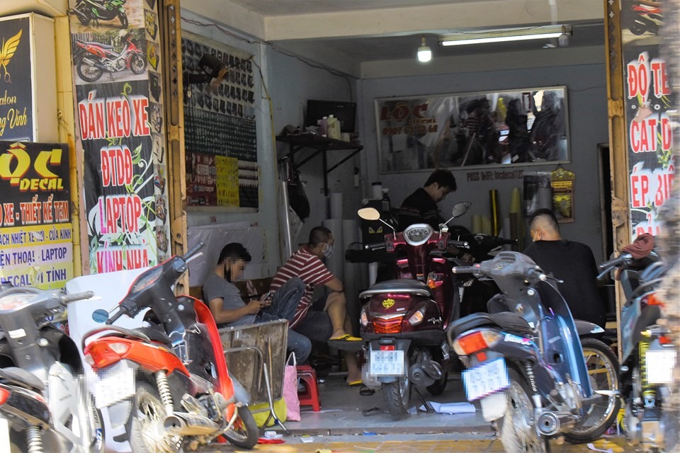 Tại đường Hùng Vương, nhiều cửa hàng dán keo, trang trí xe máy tập nập người ra vào. Ảnh chụp vào trưa ngày 17.4.
