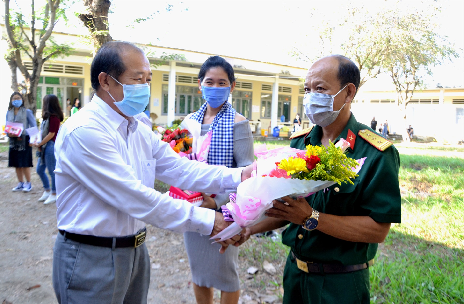 Ông Đoàn Tấn Bửu tặng hoa cho đại diện lực lượng hoàn thành xuất sắc nhiệm vụ trong thời gian quản lý điểm cách ly. Ảnh: LT