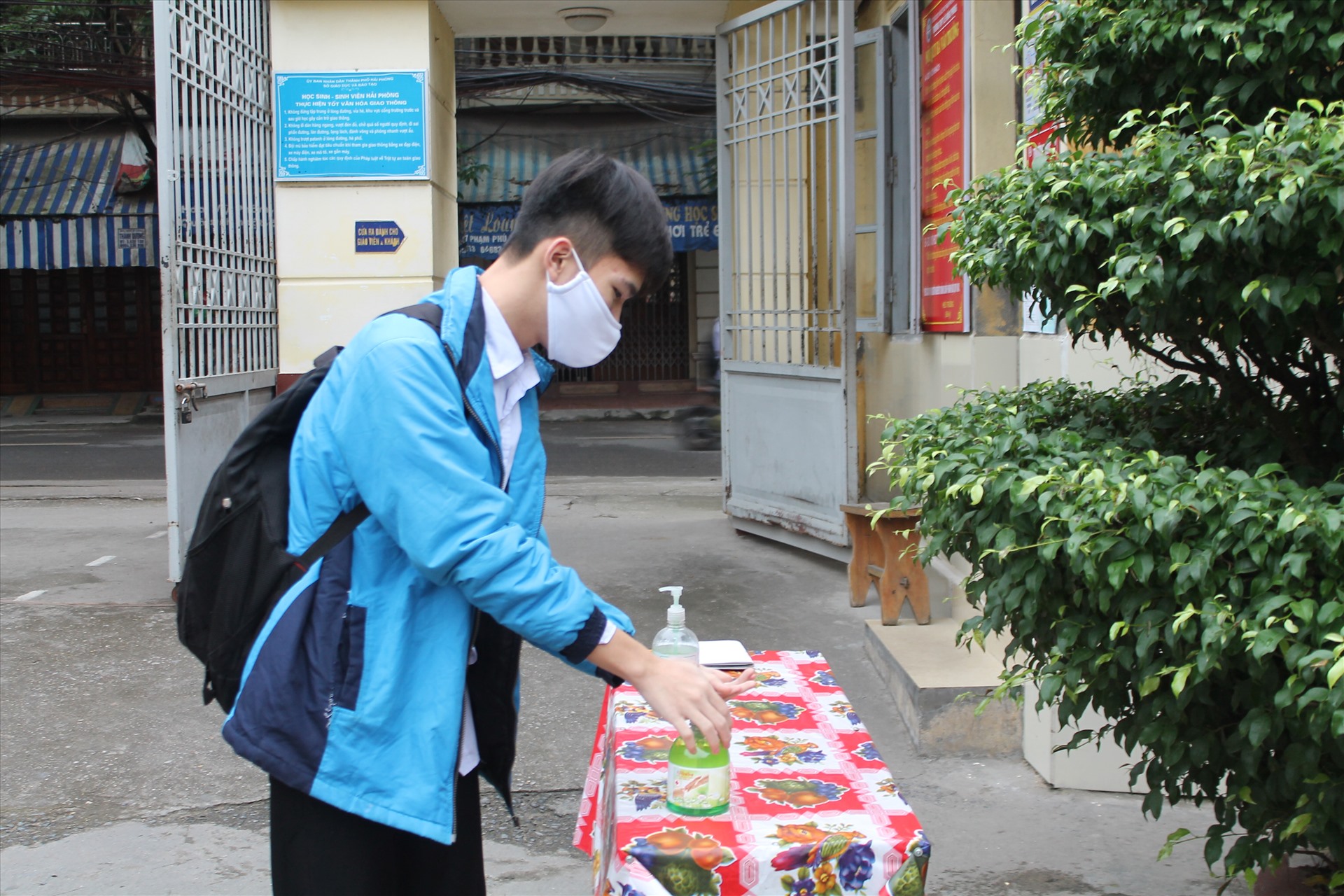 Học sinh rửa tay sát khuẩn từ cổng trường. Ảnh Mai Dung