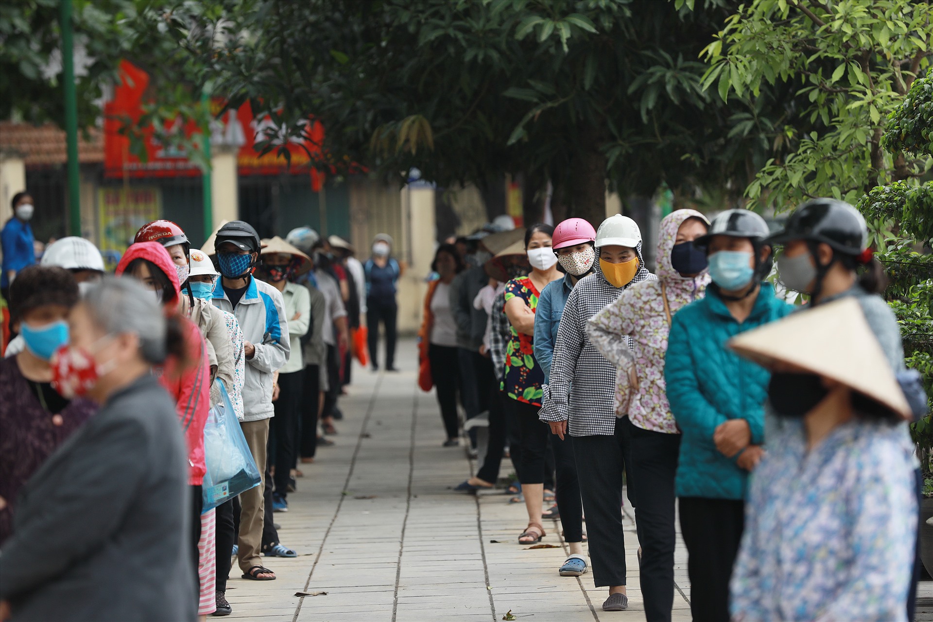 10h sáng 17.4, tại điểm phát gạo Nghĩa Tân, dòng người xếp hàng nhận gạo với khoảng cách 2m gần kín sân vận động.