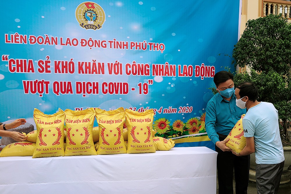 Đồng chí Hà Đức Quảng - Chủ tịch LĐLĐ tỉnh, các đồng chí lãnh đạo LĐLĐ tỉnh trao gạo cho công nhân. Ảnh: Mai Hoa