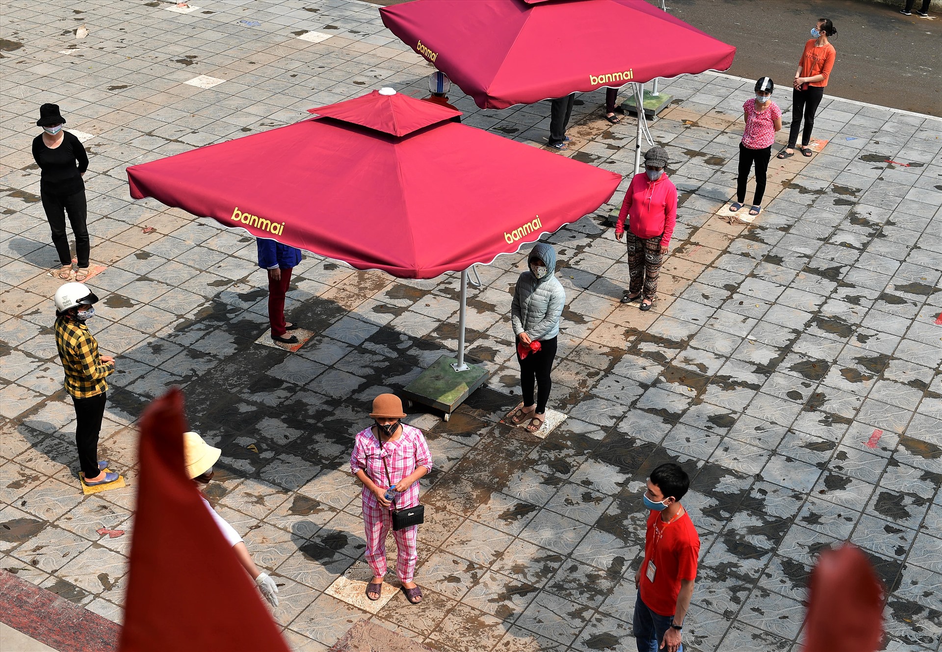 Những người dân đứng cách nhau 2m chờ lấy gạo ở cây “ATM” gạo ở Trung tâm văn hóa thể thao phường Nghĩa Tân (Hà Nội).