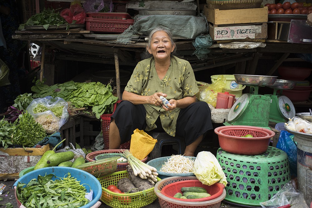 Nụ cười hiền hòa của bà cụ bán rau ở chợ Cũ (chụp năm 2015).